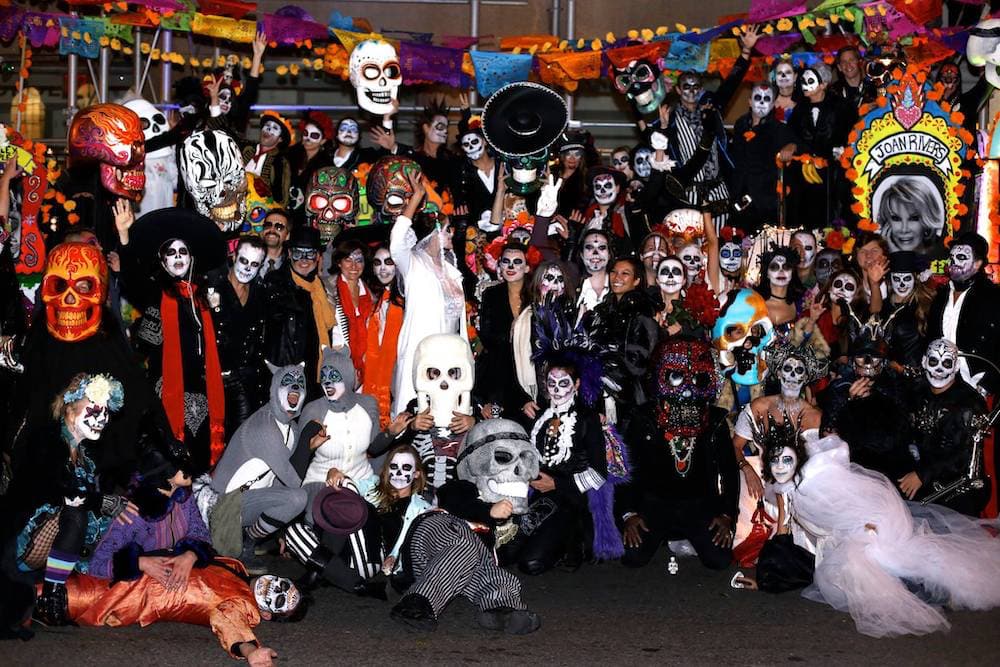 Group of roughly 30 people all dressed up in halloween masks and costumes