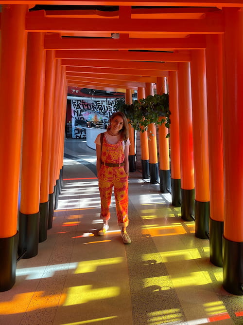 Harriet stood beneath a row of red gates that resemble Japanese 'torii' gates.